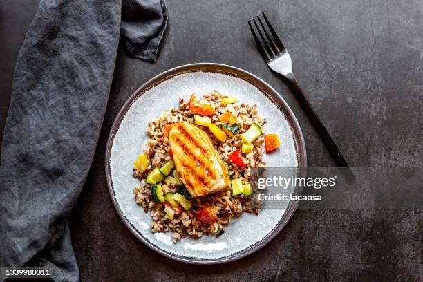 roasted salmon with wild rice and vegetables - food top view stock-fotos und bilder