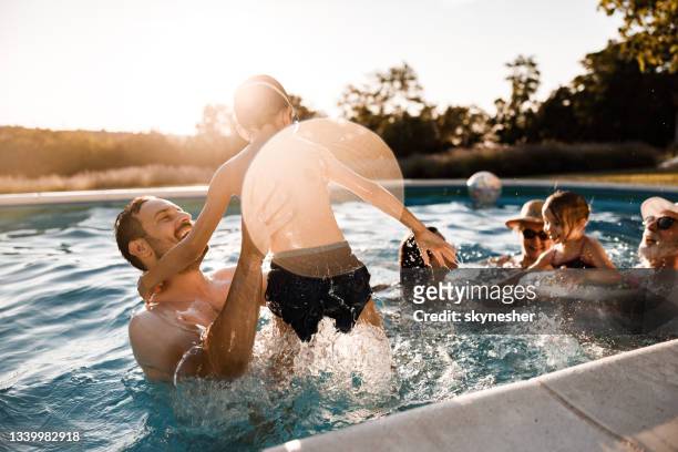fröhlicher vater und sohn beim spaß im schwimmbad. - family pool stock-fotos und bilder