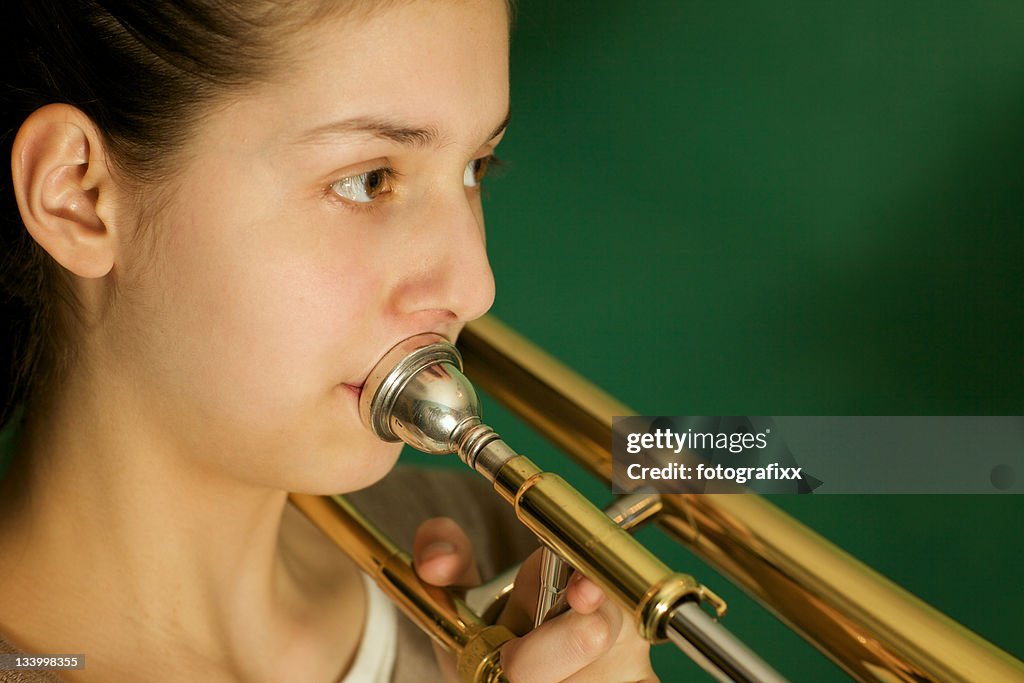 Close up: "Adolescente prática o trombone"