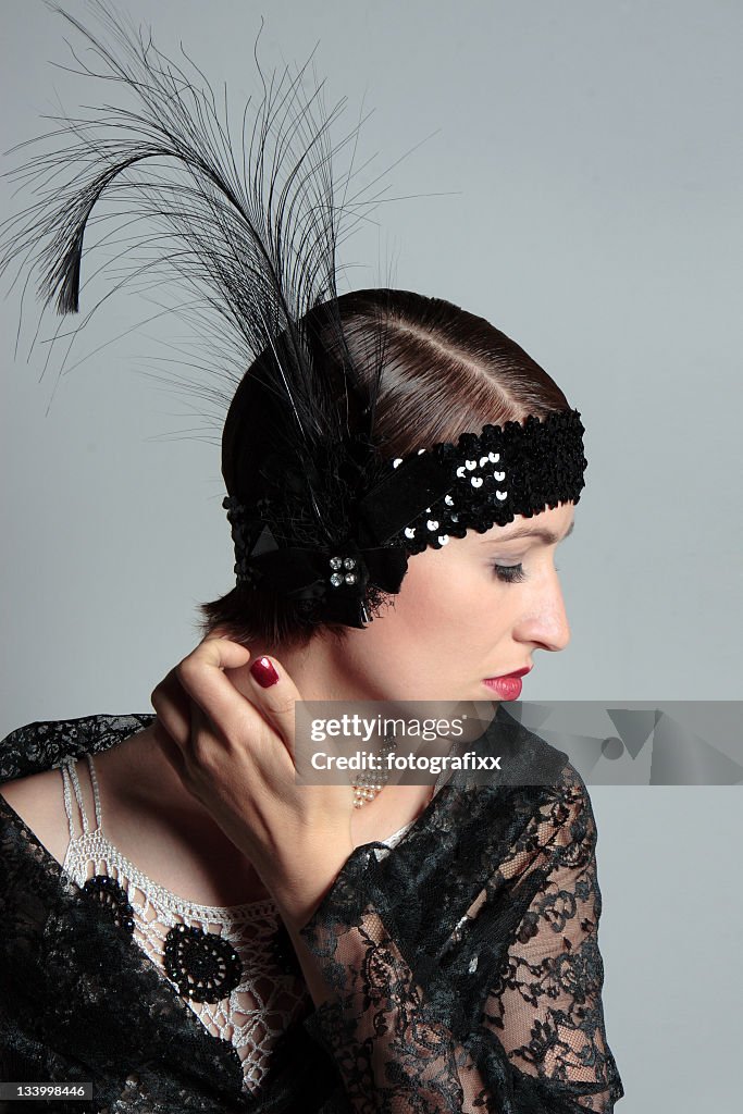 Woman in retrow look of 1920s with feather hair band