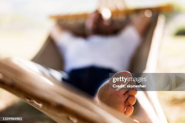 close up of man's foot during relaxing time in hammock. - backyard hammock stock pictures, royalty-free photos & images