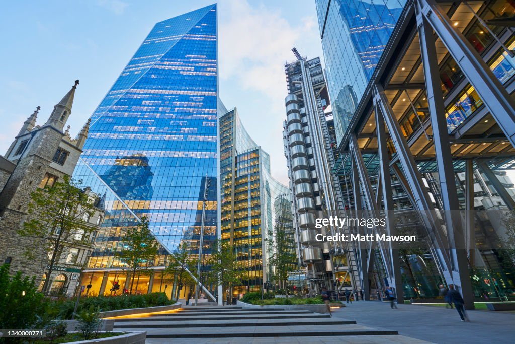 Low angle view at dusk looking down Lime Street to Lloyds of London Building, The Scalpel Building and The Leadenhall Building in the City of London UK