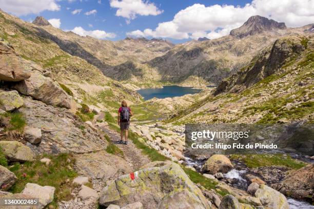 woman in ibones azules mountain lakes, aragonese pyrenees, tena valley, panticosa, spain. - provincia de huesca fotografías e imágenes de stock