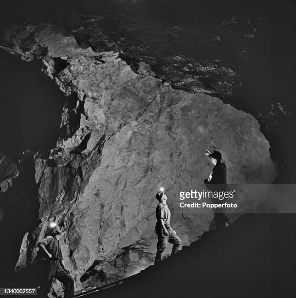 Three tin miners stand up in a 'stope', a chamber blasted out of the rock for mining ore, at East Pool tin mine near Camborne in Cornwall, England...