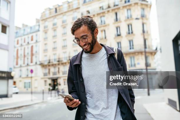 modern young man with curly hair in the city - paris tourist stock pictures, royalty-free photos & images