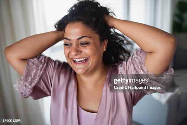 portrait of beautiful young overweight woman indoors at home, looking at camera. - woman in bathrobe stock pictures, royalty-free photos & images