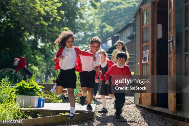 running to play - primary school children in uniform stock pictures, royalty-free photos & images