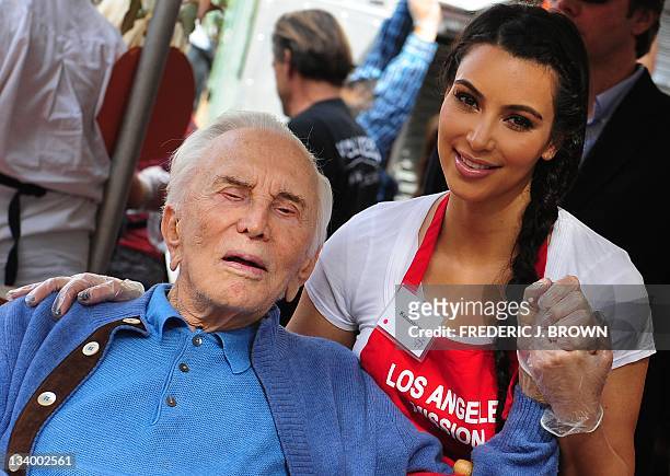 Actor Kirk Douglas and socialite Kim Kardashian pose for photos as celebrities turn out to feed the homeless and those less fortunate a lunchtime...