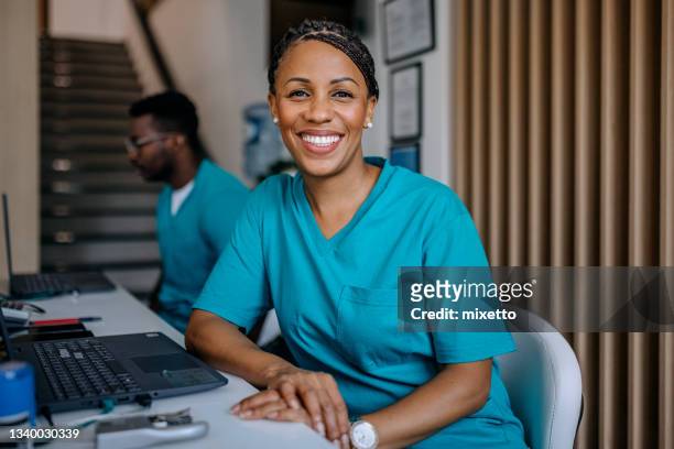 enfermeira feliz trabalhando no hospital - medical scrubs - fotografias e filmes do acervo
