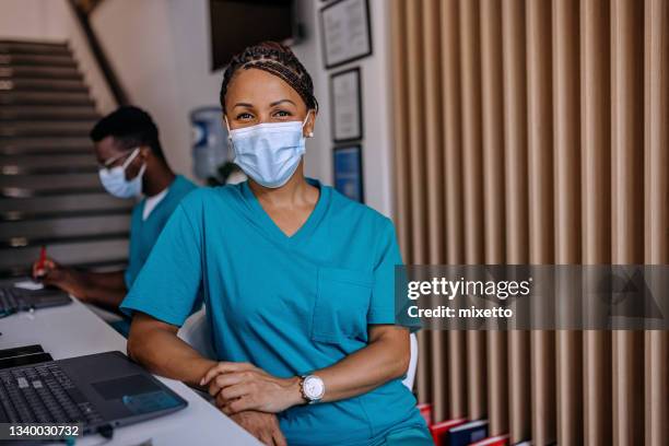 glückliche krankenschwester, die im krankenhaus arbeitet - assistent stock-fotos und bilder