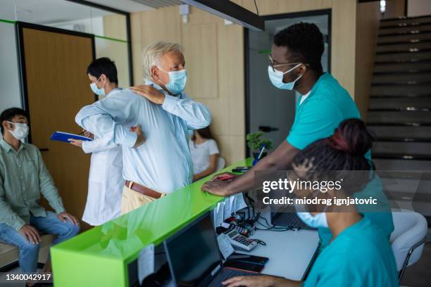 busy day in medical clinic - healthcare worker in mask stock pictures, royalty-free photos & images