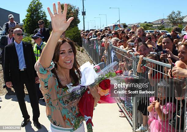 Princess Mary of Denmark waves to the crowd of people after touring an environmentally-friendly building at Pakenham Springs Primary School on...