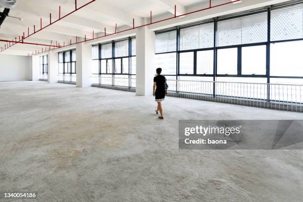 woman walking in new office building - warehouse floor stock pictures, royalty-free photos & images