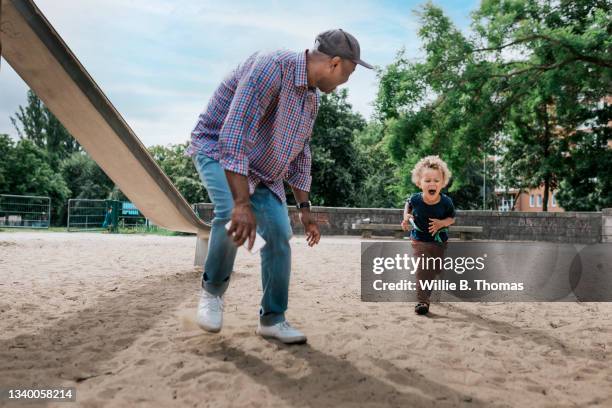 grandfather having fun with grandson in playground - boy curly blonde stock pictures, royalty-free photos & images