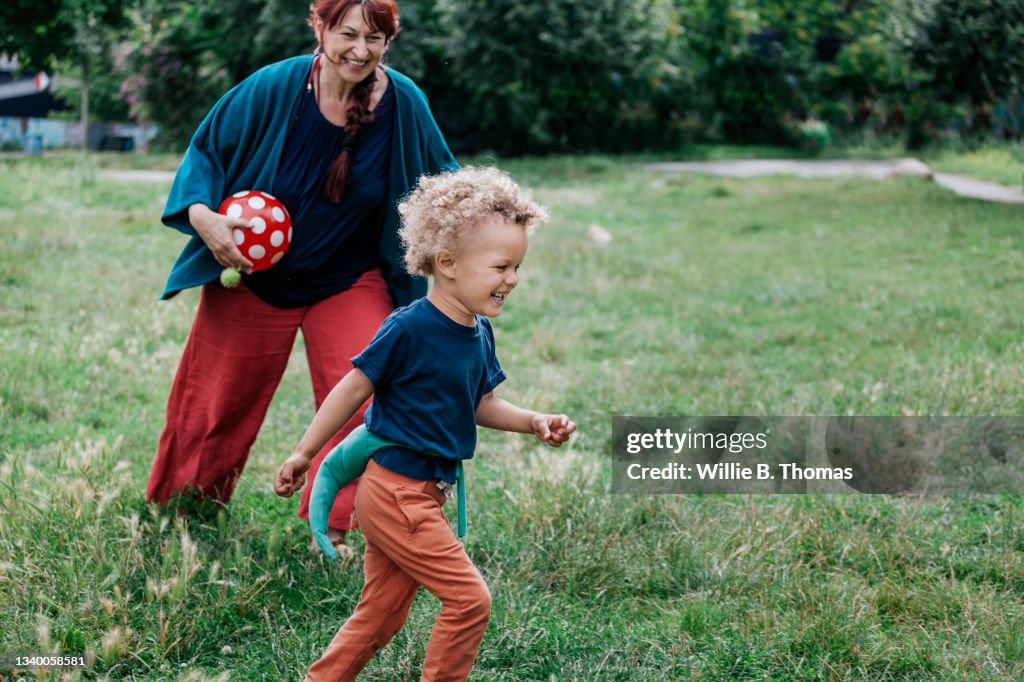 Young Boy Running In Park With Grandmother