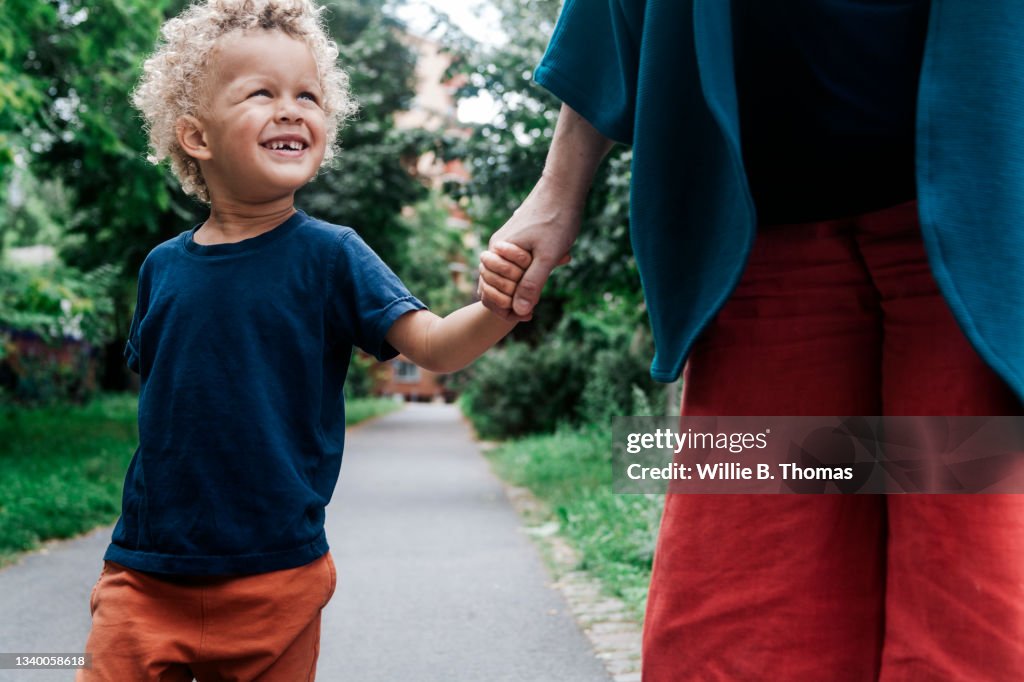 Young Boy Smiling While Holding Grandmothers Hand