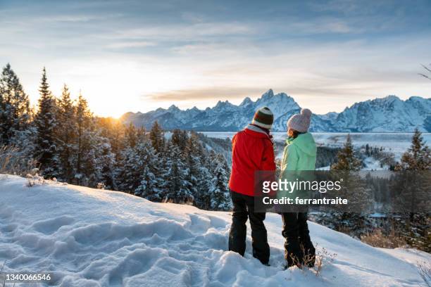 mother and teenage daughter enjoying the winter views - grand teton national park sunset stock pictures, royalty-free photos & images
