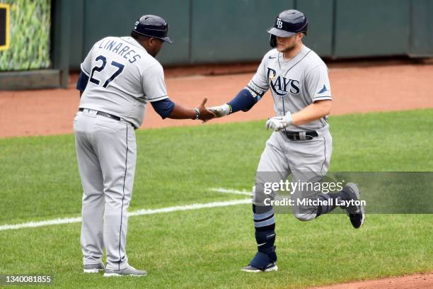 Austin Meadows of the Tampa Bay Rays celebrates a home run with third base coach Rodney Linares during a baseball game against the Baltimore Orioles...