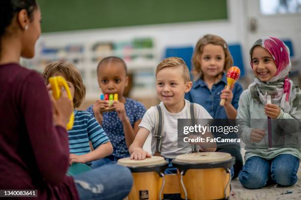 kindergarten children playing with musical instruments in class - preschool student stock pictures, royalty-free photos & images