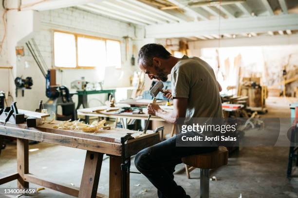 carpenter hammering chisel - chisel fotografías e imágenes de stock