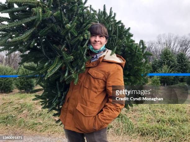 man carrying a freshly cut christmas tree - cut out happy ストックフォトと画像