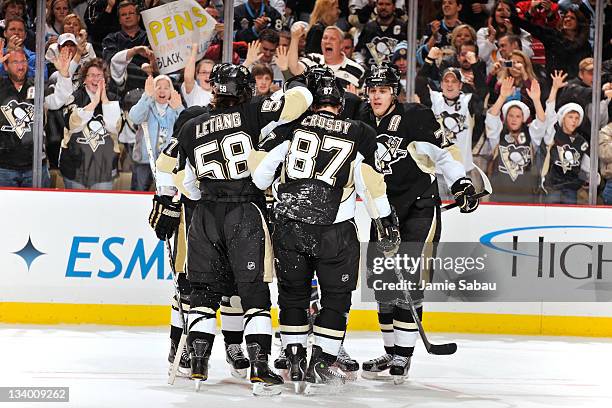 Kris Letang, Sidney Crosby and Evgeni Malkin, all of the Pittsburgh Penguins, celebrate a goal by teammate James Neal of the Pittsburgh Penguins...