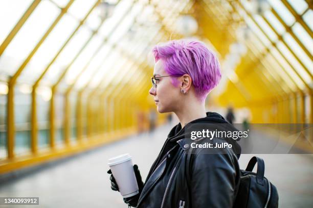 young woman with disposable coffee cup walking outdoors - coffee cup disposable stock pictures, royalty-free photos & images