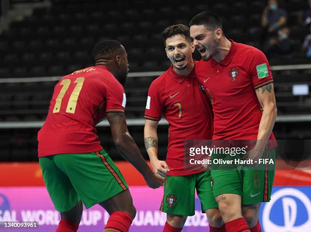 Erick of Portugal celebrates with teammates Bruno Coelho and Pany after scoring their team's second goal during the FIFA Futsal World Cup 2021 group...
