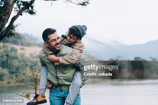 Father carrying son on his back Father carrying son on his back