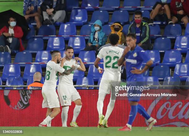 Lucas Perez of Elche celebrates with Dario Benedetto after scoring their team's first goal during the La Liga Santander match between Getafe CF and...