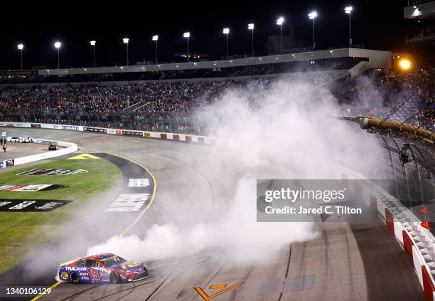 Martin Truex Jr., driver of the Bass Pro Shops Red White Blue Toyota, celebrates with a burnout after winning the NASCAR Cup Series Federated Auto...