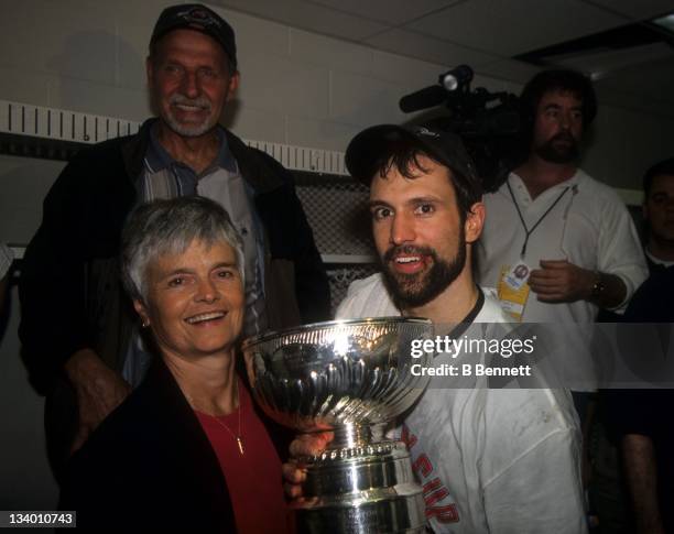 Scott Niedermayer of the New Jersey Devils celebrates in the locker room with the Stanley Cup Trophy with his mother Carol after Game 6 of the 2000...