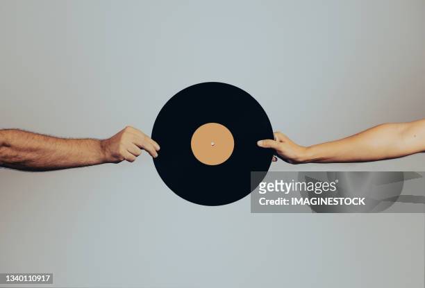 close-up of two hands holding vinyl record - album cover stock-fotos und bilder