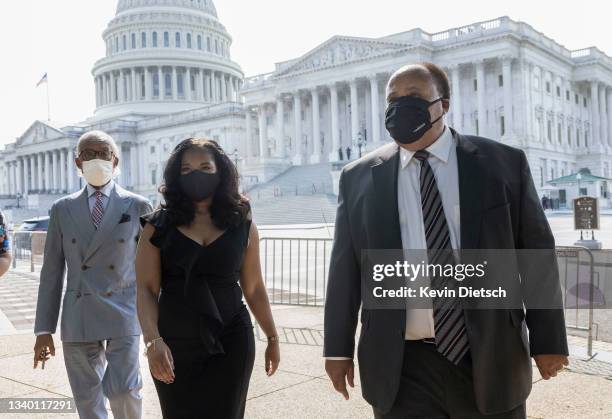 Cilvil rights leaders Martin Luther King III, Andrea Waters King, and Rev. Al Sharpton walk to a press conference on voting rights outside of the...