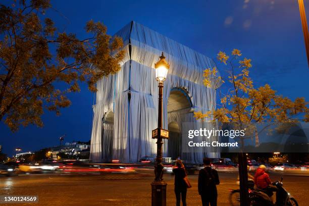 The wrapping of the Arc de Triomphe as part of an art installation by the late artist Christo is seen on the night on September 13, 2021 in Paris,...