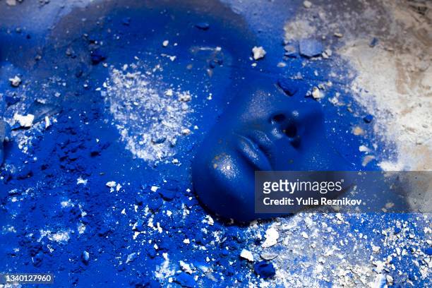 blue colored face mask on the blue painted background. - artistic makeup stock-fotos und bilder