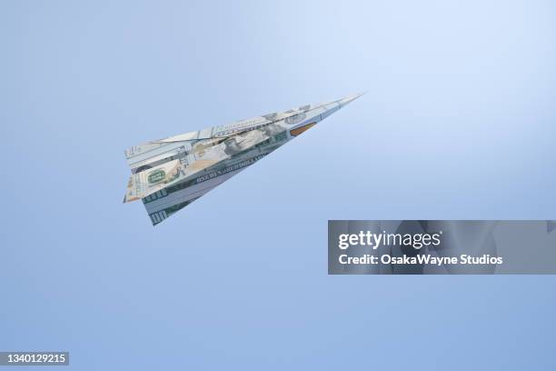 flying paper airplane against pastel blue background - money texture 個照片��及圖片檔