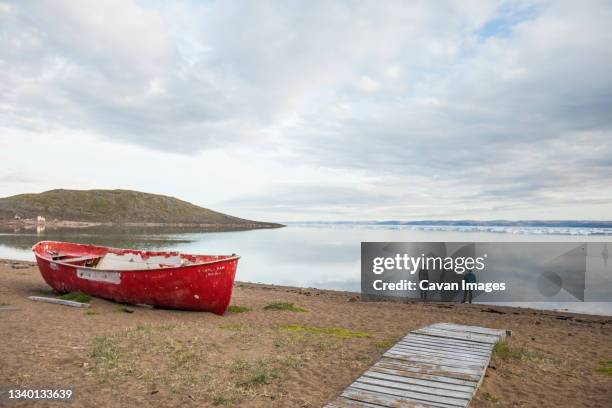 two men stand on the shoreline looking at icebergs in iqaluit, canada - iqaluit stock pictures, royalty-free photos & images