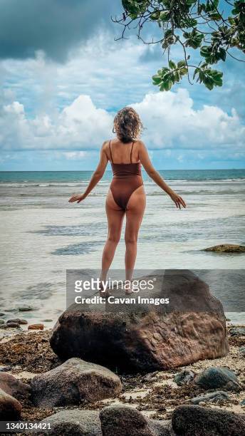 white woman standig on the rock with hands half raised - cellulite stock-fotos und bilder