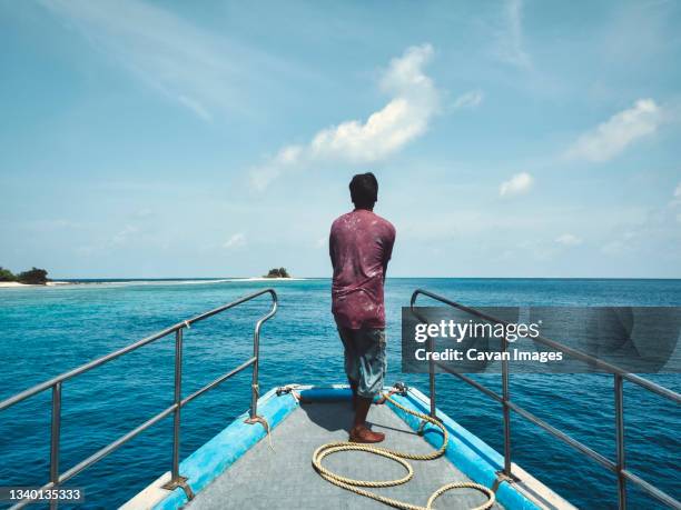 rear view of fisherman at the boat - maldives boat stock pictures, royalty-free photos & images