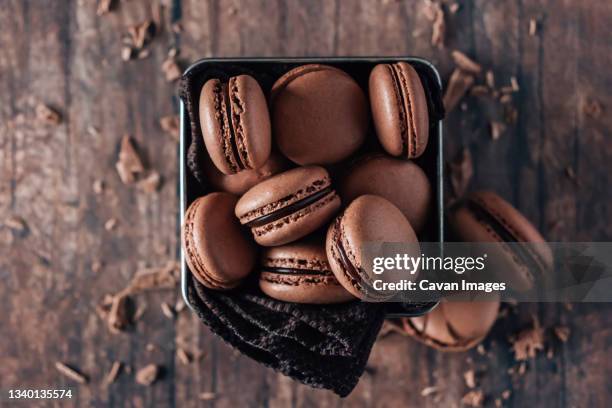 chocolate macarons on wooden table - macaroon photos et images de collection