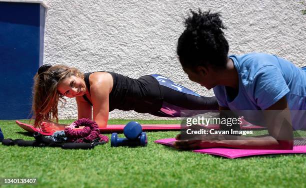 sporty multiracial women doing elbow plank exercise - core strength stock pictures, royalty-free photos & images