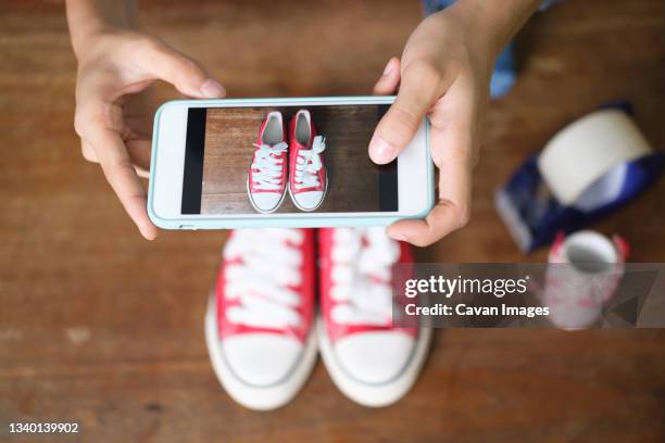 online seller owner take a photo of product for upload to websit - upload and sell stock pictures, royalty-free photos & images