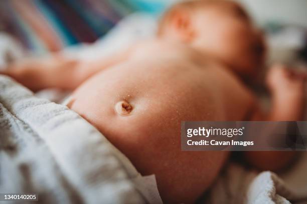 close up of newborn baby belly button and dry skin - baby touching belly fotografías e imágenes de stock