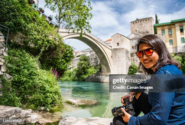 woman taking picture of the iconic bridge stari most in mostar - mostar stock pictures, royalty-free photos & images