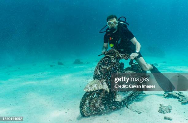 diver posing on motorbike on the ocean floor at phuket - moto humour photos et images de collection