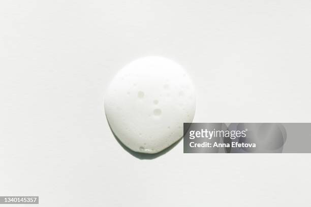drop of white foam on white background. facial cleanser for perfect skin. macrophotography in flat lay style - couleur crème photos et images de collection