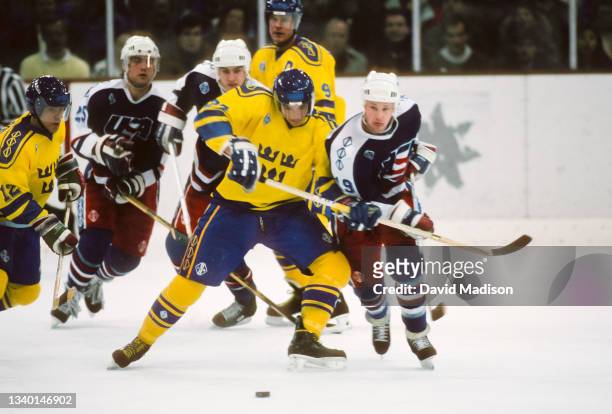 Hakan Loob, Carl Young, and Thomas Rundquist of Sweden, Sean Hill and Scott Young of the United States play in the first round of the Ice Hockey...