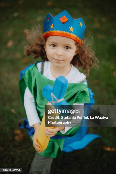 little girl wearing a knight costume and looking with confidence at the camera - mascara carnaval imagens e fotografias de stock