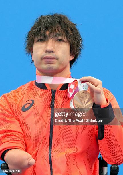 Bronze medalist Takayuki Suzuki of Team Japan poses on the podium at the medal ceremony for the Swimming Men's 150m Individual Medley - SM4 on day 4...